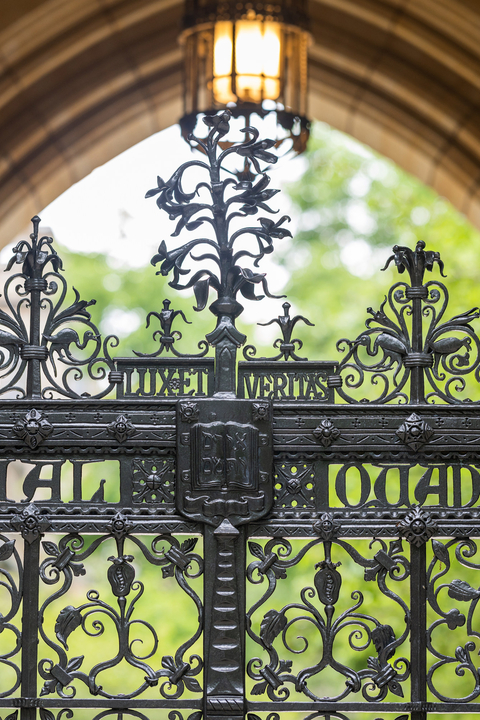 The intricate, wrought iron gate of the Memorial Quadrangle features the Yale motto Lux et Veritas and coat of arms
