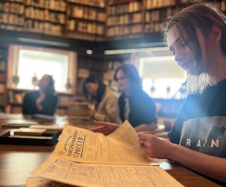 Female student reading a newspaper